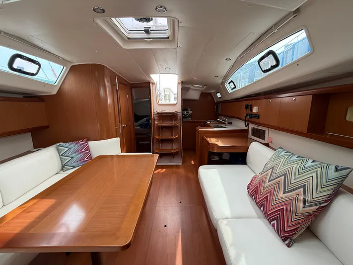 Deep Unreal Yacht Photos Pics Interior of 2008 Beneteau Oceanis 40 sailboat with wood finish and colorful cushions.