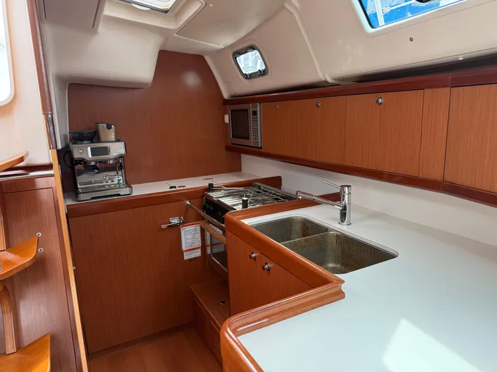 Deep Unreal Yacht Photos Pics Galley kitchen in 2008 Beneteau Oceanis 40 yacht with wood cabinetry and modern appliances.