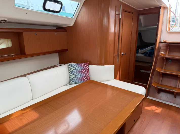 Deep Unreal Yacht Photos Pics Interior of 2008 Beneteau Oceanis 40 yacht with wooden finish and white seating.