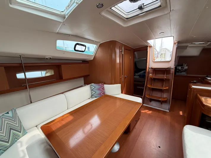 Deep Unreal Yacht Photos Pics Interior of 2008 Beneteau Oceanis 40 sailboat with wooden furnishings and white seating.