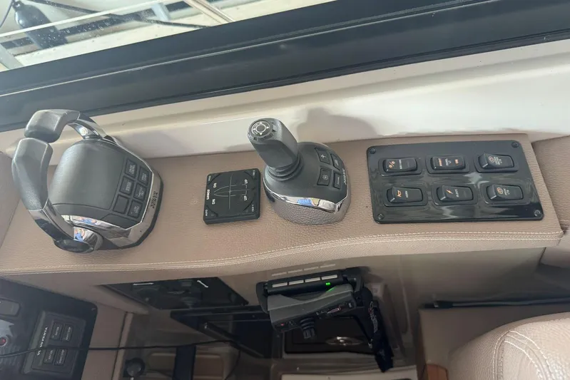  Yacht Photos Pics Control panel of a 2016 Regal 46 Sport Coupe yacht, featuring joystick and switches.