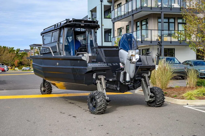  Yacht Photos Pics Amphibious StabiX 240UCC boat with wheels, 2024 model, parked near modern building.