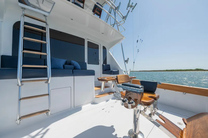 Walk West Yacht Photos Pics 2001 Viking Convertible yacht deck with seating, ladder, and ocean view.