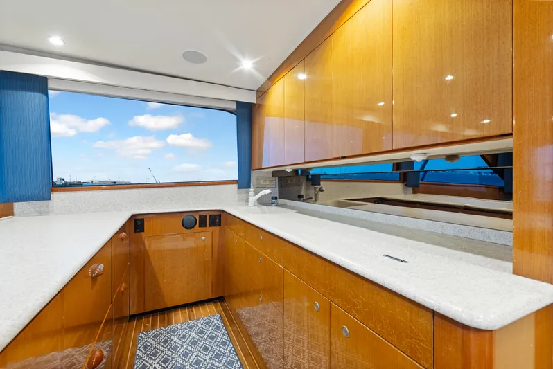 Walk West Yacht Photos Pics Luxurious kitchen interior of a 2001 Viking Convertible yacht with wooden cabinets and ocean view.