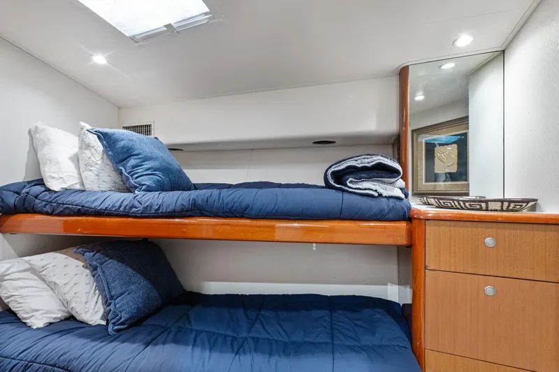 Walk West Yacht Photos Pics Bunk beds in a 2001 Viking Convertible yacht cabin with blue bedding and wooden cabinetry.