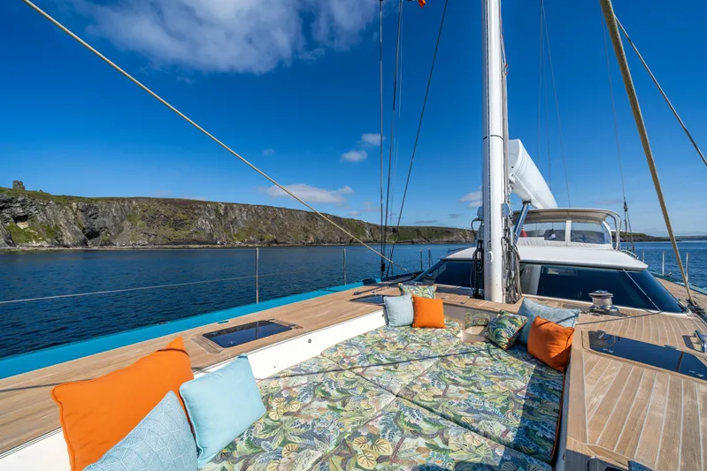 Karibu Yacht Photos Pics Luxurious 2013 Oyster 885 yacht deck with colorful cushions, scenic coastal view.