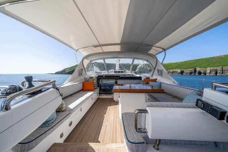 Karibu Yacht Photos Pics Luxurious 2013 Oyster 885 yacht deck with seating, ocean view, and coastal backdrop.