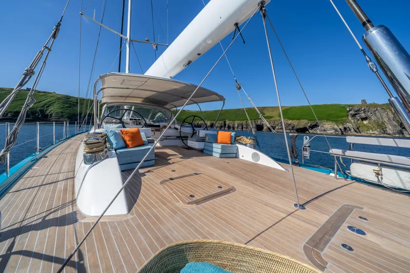 Karibu Yacht Photos Pics Luxurious 2013 Oyster 885 yacht deck with seating, sailing near scenic coastline.