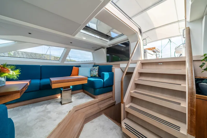 Karibu Yacht Photos Pics Luxurious interior of 2013 Oyster 885 yacht with blue seating and wooden accents.