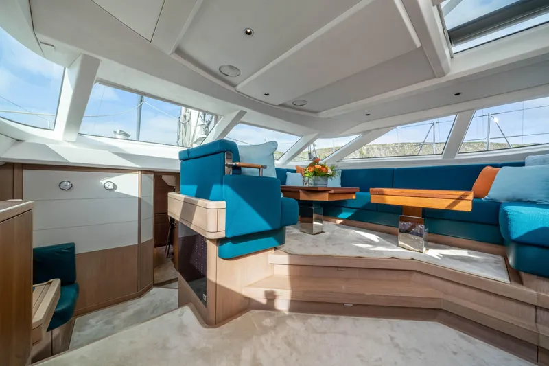 Karibu Yacht Photos Pics Luxurious interior of 2013 Oyster 885 yacht with blue seating and wooden accents.