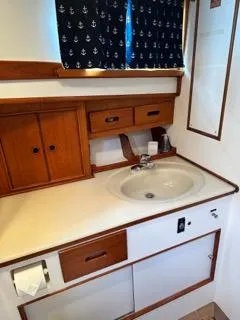 Its About Time Yacht Photos Pics Bathroom interior of a 1996 Grand Banks Classic yacht with wooden cabinetry and nautical curtains.