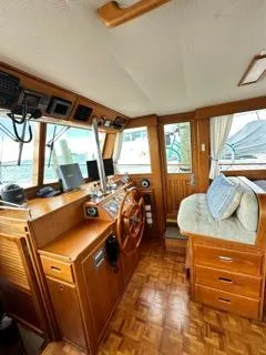 Its About Time Yacht Photos Pics Interior of a 1996 Grand Banks Classic boat with wooden helm and seating area.