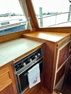 Its About Time Yacht Photos Pics 1996 Grand Banks Classic yacht kitchen with stove, wooden cabinetry, and marina view.
