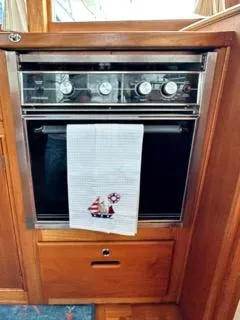 Its About Time Yacht Photos Pics 1996 Grand Banks Classic oven with nautical-themed towel in wooden interior.