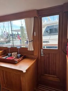 Its About Time Yacht Photos Pics Interior view of 1996 Grand Banks Classic yacht with wooden cabinetry and dockside window.