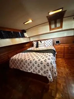 Its About Time Yacht Photos Pics 1996 Grand Banks Classic yacht bedroom with anchor-themed bedding and wooden interior.