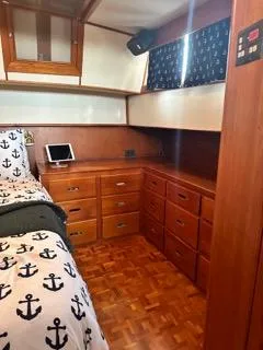 Its About Time Yacht Photos Pics Interior of 1996 Grand Banks Classic yacht with anchor-themed bedding and wooden cabinetry.
