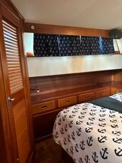 Its About Time Yacht Photos Pics Cozy 1996 Grand Banks Classic cabin with nautical-themed bedding and wooden cabinetry.