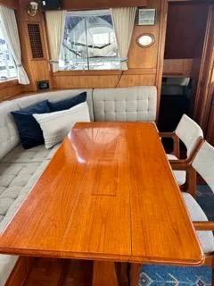 Its About Time Yacht Photos Pics Interior of 1996 Grand Banks Classic yacht with wooden table and cushioned seating.