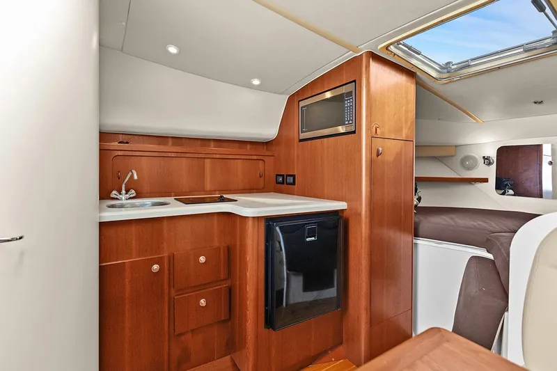  Yacht Photos Pics 2005 Tiara Open Classic yacht interior with kitchenette, featuring wood cabinetry and modern amenities.
