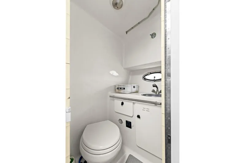  Yacht Photos Pics Compact bathroom in 2005 Tiara Open Classic boat, featuring toilet and sink.