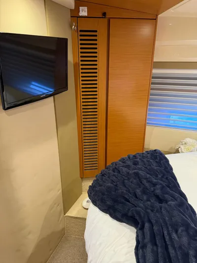 Luna Yacht Photos Pics Interior of 2014 Azimut Atlantis 45 yacht with TV, wooden cabinet, and cozy bedding.