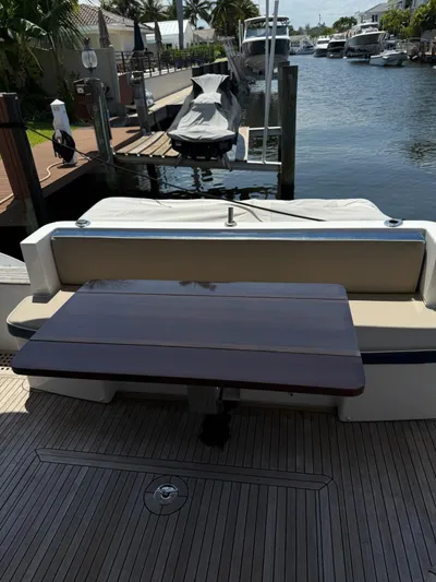 Luna Yacht Photos Pics Azimut Atlantis 45 yacht deck with wooden table, docked by a canal.