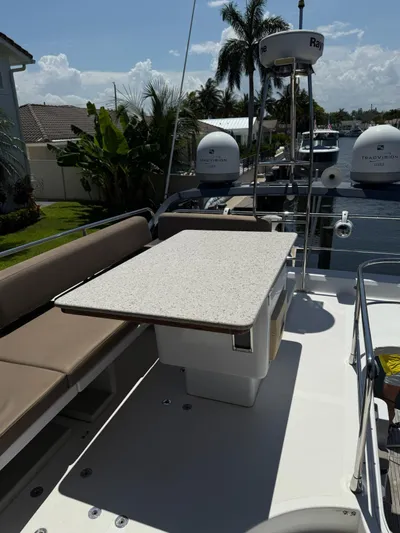 Luna Yacht Photos Pics 2014 Azimut Atlantis 45 yacht deck with seating and table, docked near palm trees.