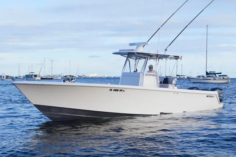  Yacht Photos Pics 2014 Contender 39 ST boat on calm water with fishing rods and other boats in the background.