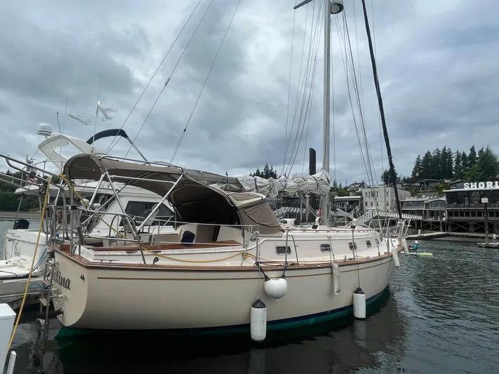  Yacht Photos Pics 1995 Island Packet 40 sailboat docked in a marina, under cloudy skies.