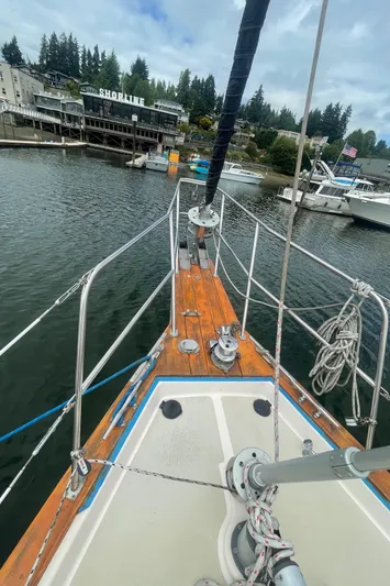  Yacht Photos Pics Bow view of 1995 Island Packet 40 sailboat docked near shoreline buildings.