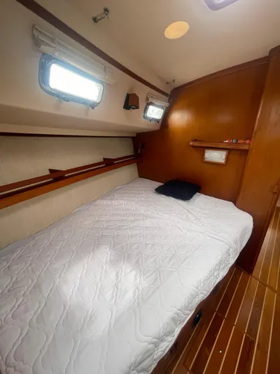  Yacht Photos Pics Cozy cabin interior of 1995 Island Packet 40 sailboat with bed and wooden accents.