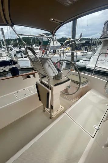  Yacht Photos Pics Cockpit of 1995 Island Packet 40 sailboat, featuring steering wheel and seating, docked at marina.