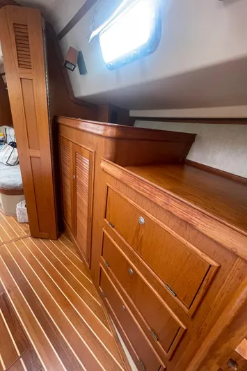  Yacht Photos Pics Interior of 1995 Island Packet 40 sailboat with wooden cabinetry and striped flooring.