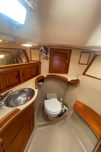  Yacht Photos Pics 1995 Island Packet 40 yacht bathroom with wooden cabinetry and stainless steel sink.