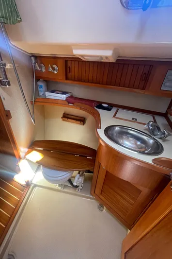  Yacht Photos Pics Island Packet 40 yacht bathroom, 1995 model, featuring wooden cabinetry, sink, and compact toilet.