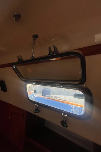  Yacht Photos Pics Open porthole on 1995 Island Packet 40 sailboat, sunlight streaming through.