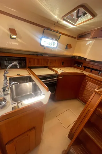  Yacht Photos Pics 1995 Island Packet 40 yacht kitchen with sink, stove, and wooden cabinetry.
