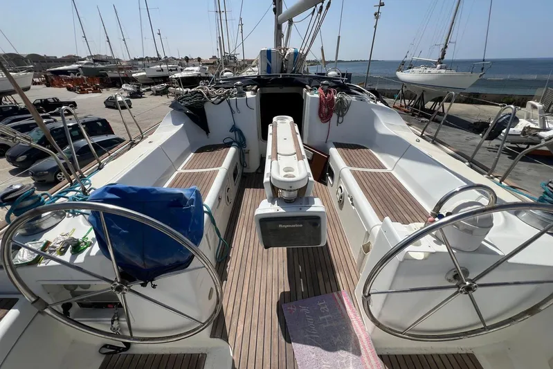 Roberto Goracci Yacht Photos Pics 2003 Beneteau Oceanis Clipper 473 sailboat cockpit with dual steering wheels and wooden deck.