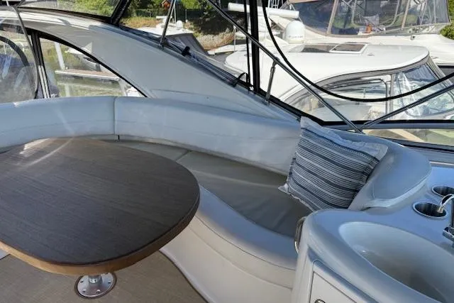  Yacht Photos Pics 2008 Meridian 391 Sedan interior with curved seating, table, and striped pillow.