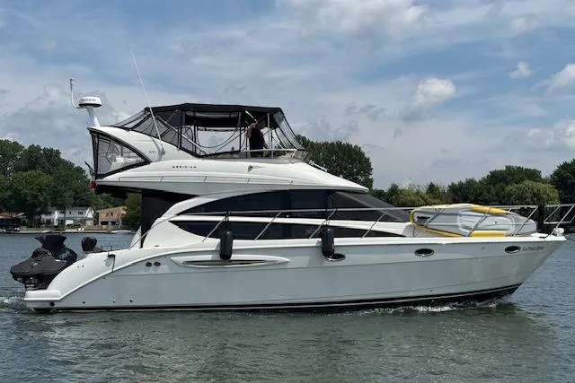  Yacht Photos Pics 2008 Meridian 391 Sedan yacht cruising on a calm lake under a partly cloudy sky.