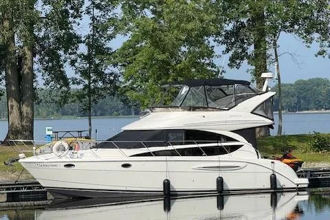  Yacht Photos Pics 2008 Meridian 391 Sedan yacht docked by a serene lakeside with lush trees.