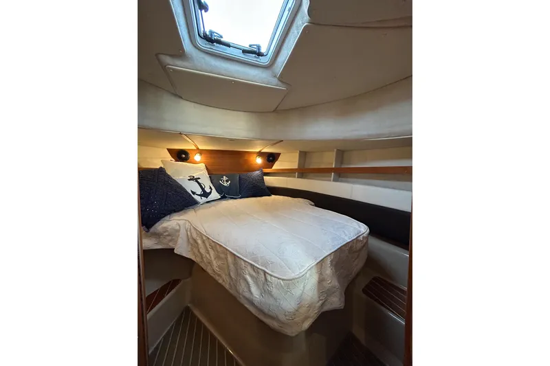  Yacht Photos Pics Cozy cabin interior of 2017 Ranger Tugs R-31 CB with nautical-themed bedding.