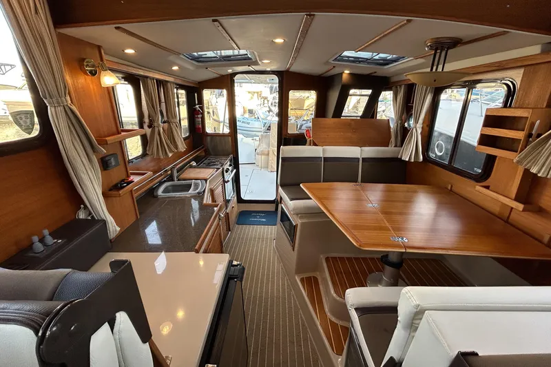  Yacht Photos Pics 2017 Ranger Tugs R-31 CB interior with wood finishes and spacious seating area.