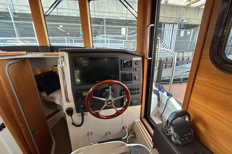  Yacht Photos Pics 2017 Ranger Tugs R-31 CB helm with wooden steering wheel and navigation controls.