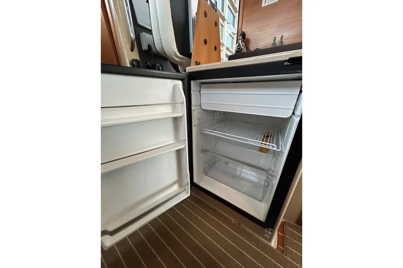  Yacht Photos Pics Open refrigerator inside 2017 Ranger Tugs R-31 CB boat, showing shelves and storage space.