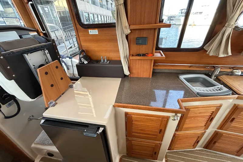  Yacht Photos Pics 2017 Ranger Tugs R-31 CB interior kitchen with wood cabinetry and compact appliances.