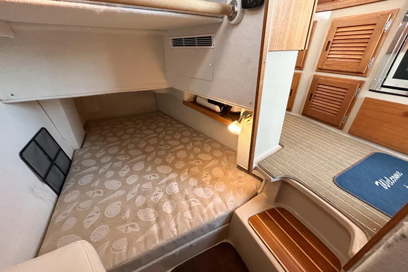  Yacht Photos Pics Cozy cabin interior of 2017 Ranger Tugs R-31 CB with patterned bedding and wooden accents.