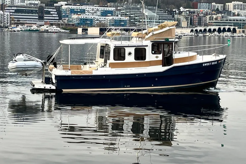 Yacht Photos Pics 2017 Ranger Tugs R-31 CB boat on calm water, urban backdrop.