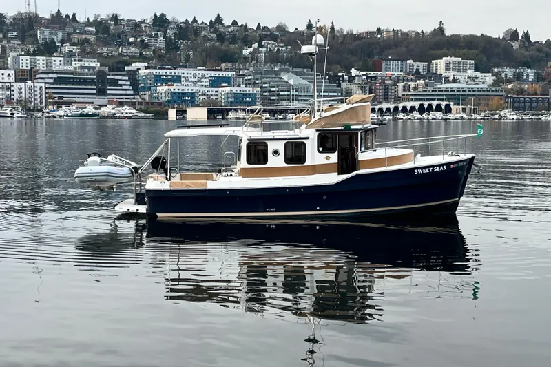  Yacht Photos Pics 2017 Ranger Tugs R-31 CB boat on calm water with cityscape background.
